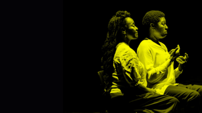 Two BSL interpreters sitting on chairs