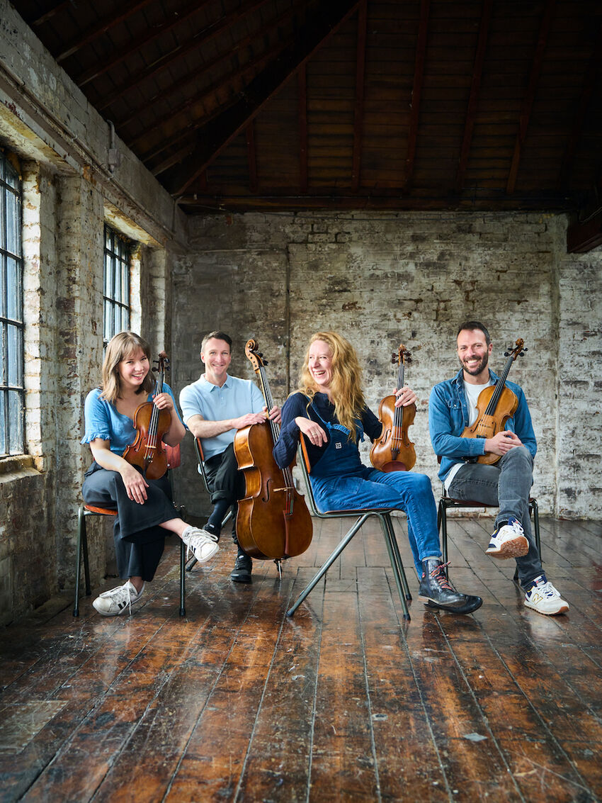 Heath Quartet posing with their string instruments