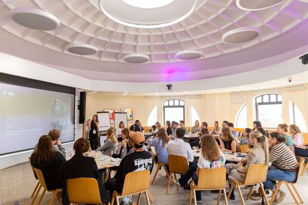 A large circular room with people sitting at scattered tables