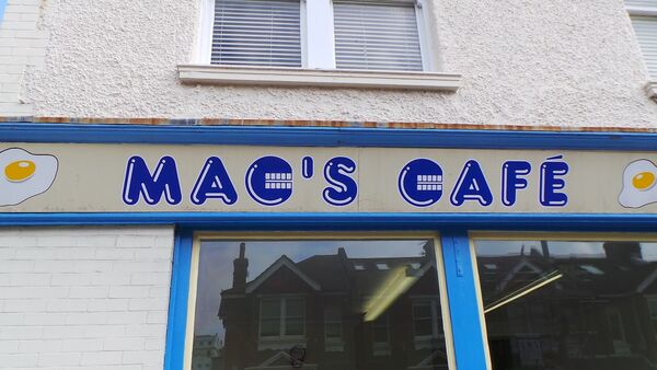 Front of Mac's Cafe, blue and white signage with fried eggs