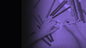 The hands of a child colouring in a sticker with felt tips