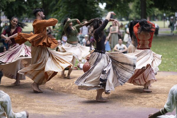 A group of five people dancing with billowing skirts