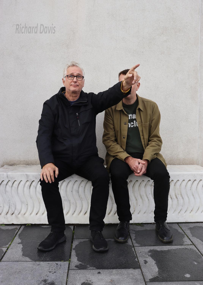 Brian Bilston and Henry Normal sitting on a wall