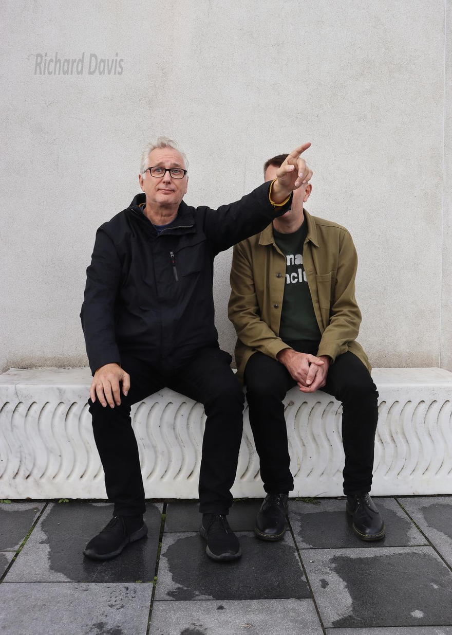 Brian Bilston and Henry Normal sitting on a wall