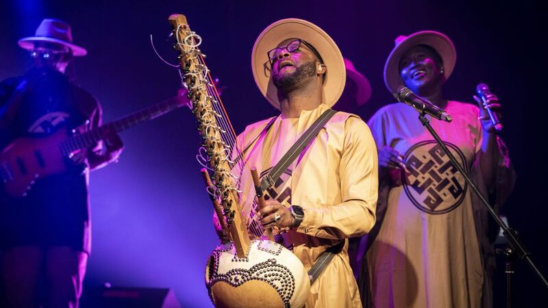 Seckou Keita plays Kora, members of the Homeland Band in the background