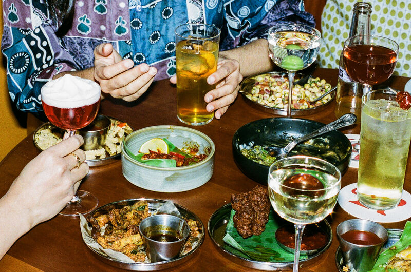 A table full of exciting food and drink with people sat around it