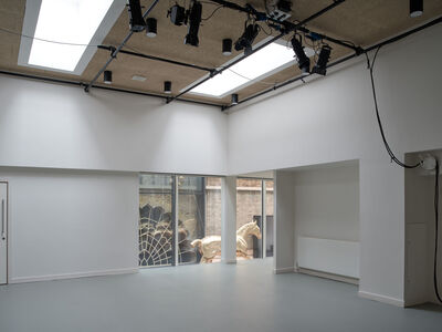 Interior shot of Anita's Room, a white walled, grey floored room