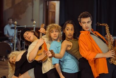 Five young people stand in a line bending backwards