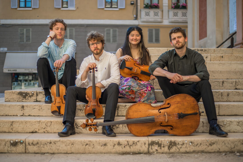 Elmore Quartet sat on stone steps with their instruments