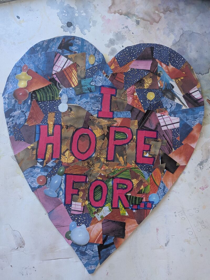 A collaged paper heart sits on a table. On the heart are the words 'I hope for'