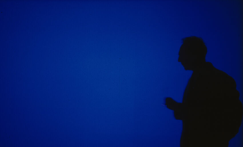 A deep blue background with a black figure silhouette