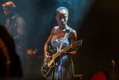 Rokia Traoré on stage playing guitar 