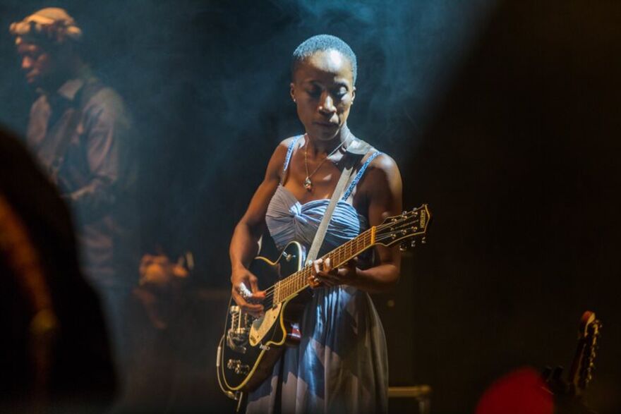 Rokia Traoré on stage playing guitar 