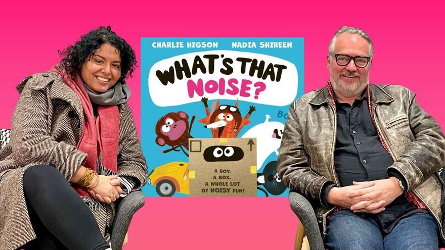 Nadia Shireen and Charlie Higson sat in chairs in front of the cover of their book 'What's That Noise?'