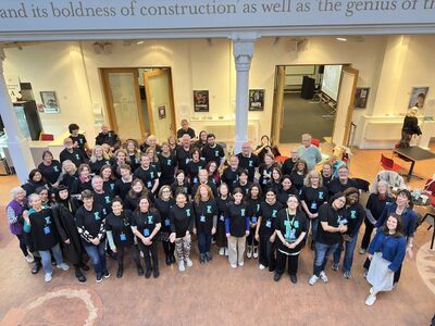 A large team of volunteers all together smile 