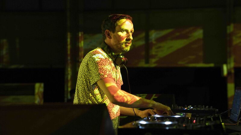 Max Cooper DJing with yellow lights over his face