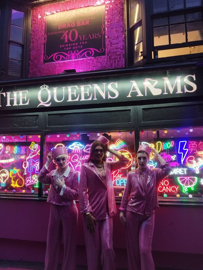 Alfie Ordianry, Alex Fincher and Billie Gold in drag wearing pink sequin suits and hates pose outside The Queens Arms drag bar