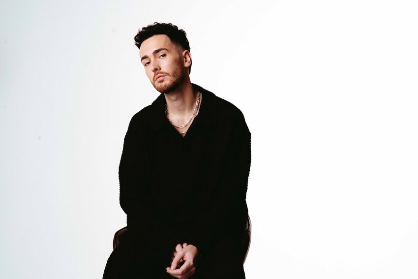 Changing Currents is dressed all in black against a plain white background. He looks directly into the camera