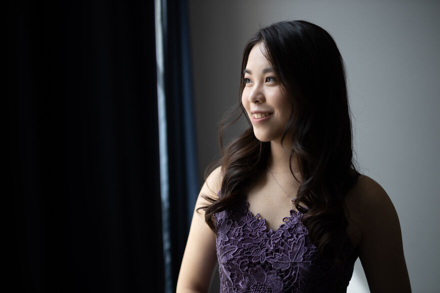 Sherri Lun wearing a purple top smiling and staring to the left