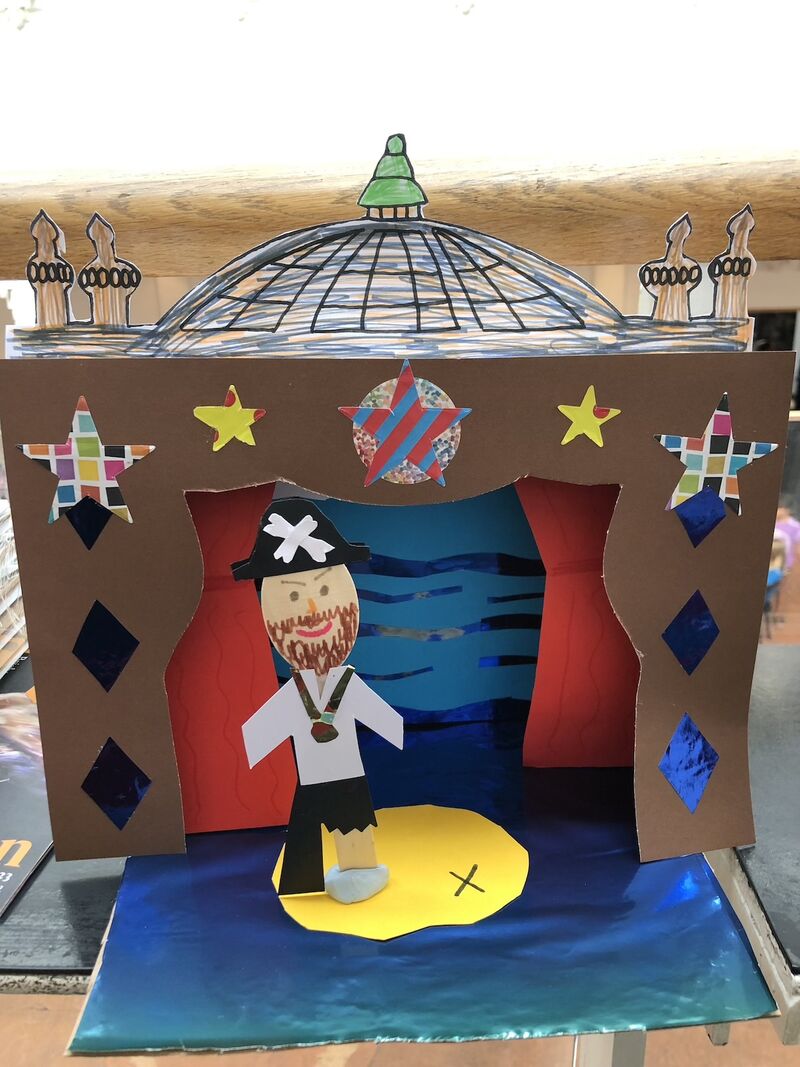 A papercraft pirate stands on a papercraft stage