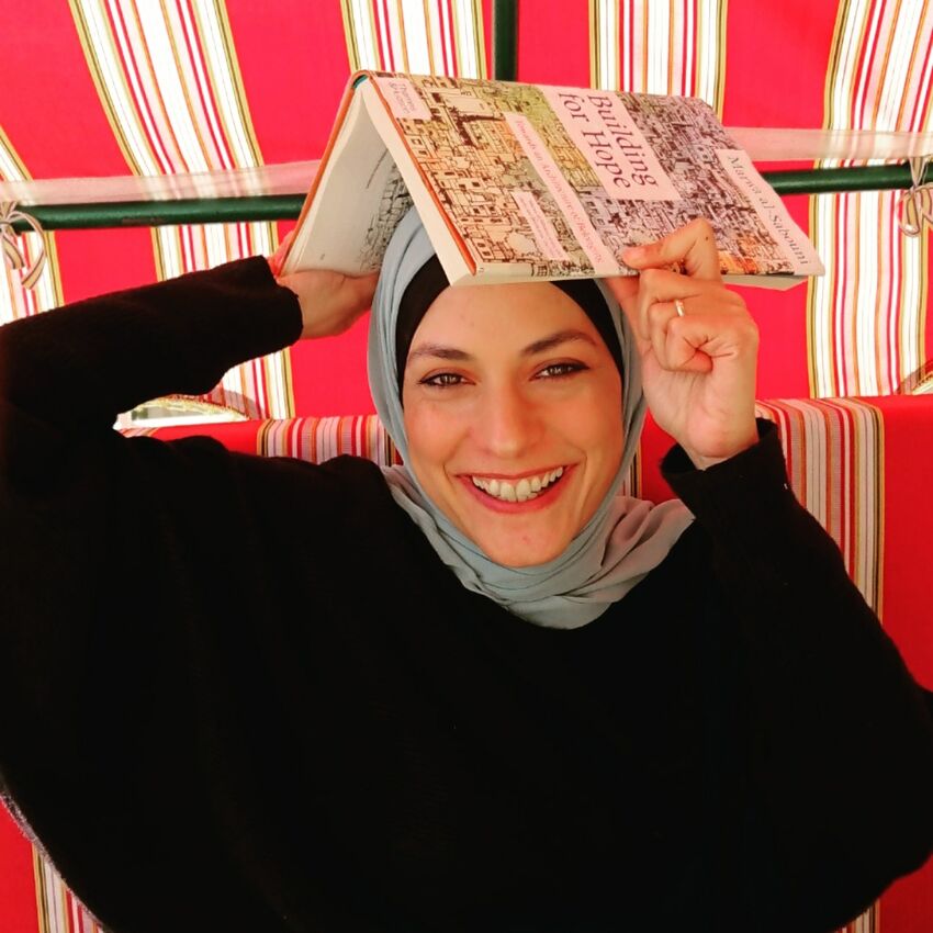 Marwa Al-Sabouni holding a book over her head