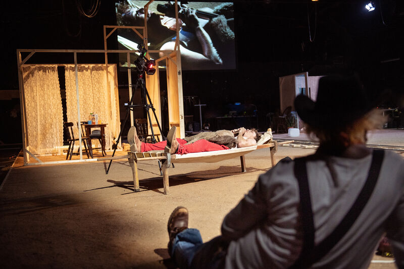 A man lays on a wooden hammock in the centre of a wooden set