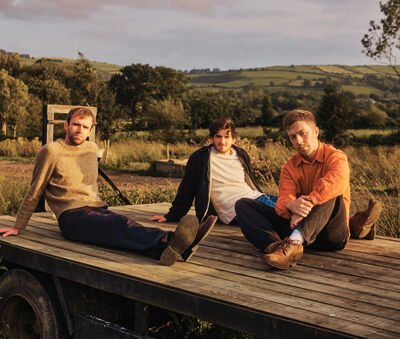 Kingfishr sitting on a wooden trailer in a field at dusk