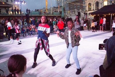 2 People dancing at an event on the seafront in Brighton near the i360, people stand around watching
