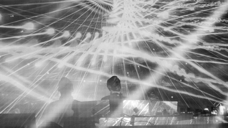 Max Cooper playing, with black and white line projections, and white laser lights