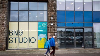 The outside of BN9 Studio, a brick building with large windows, the venue name as a poster on the left windows