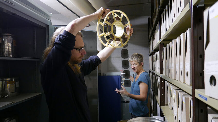 Joe Gerhardt in the CERN archives looking at a reel of film