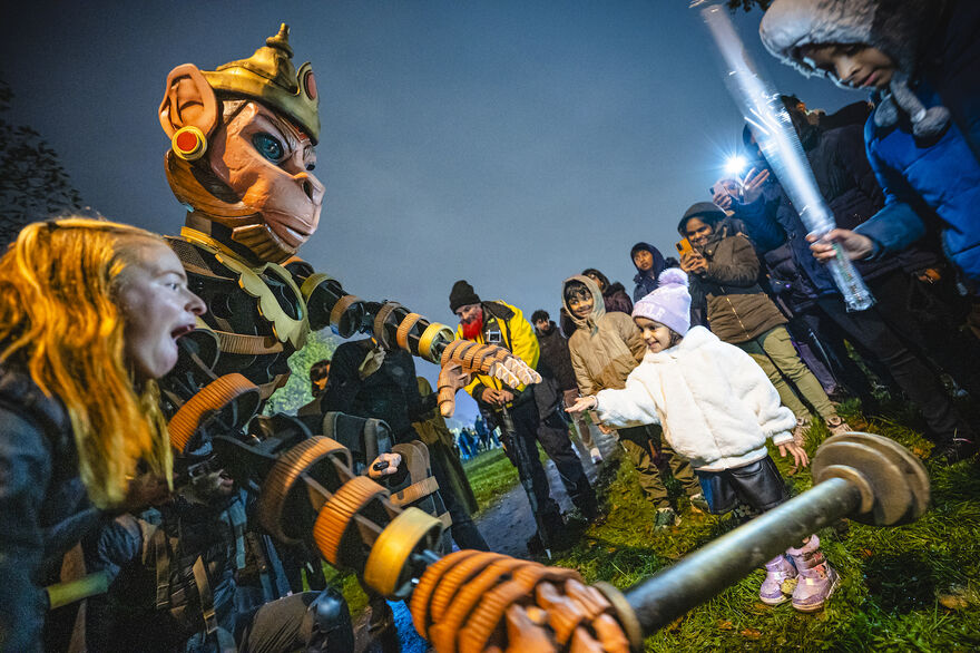 An audience interacts with a giant puppet of Hindu god Hanuman