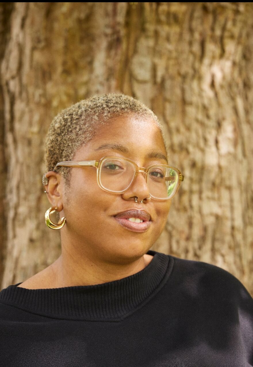 Portrait of Selina Nwulu standing in front of a tree