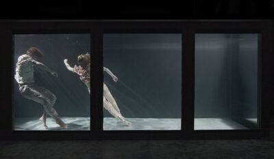 Two people submerged in a tank, their limbs float