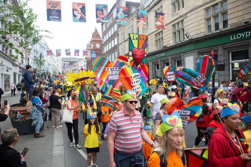 Adults and children parade through central brighton with handmade rainbow signs