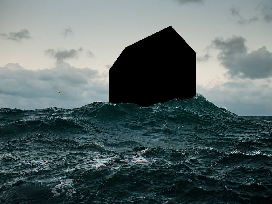 A picture of a completely blacked out house in the middle of the ocean