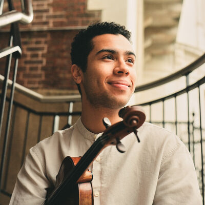 Jordan Brooks smiling holding a violin
