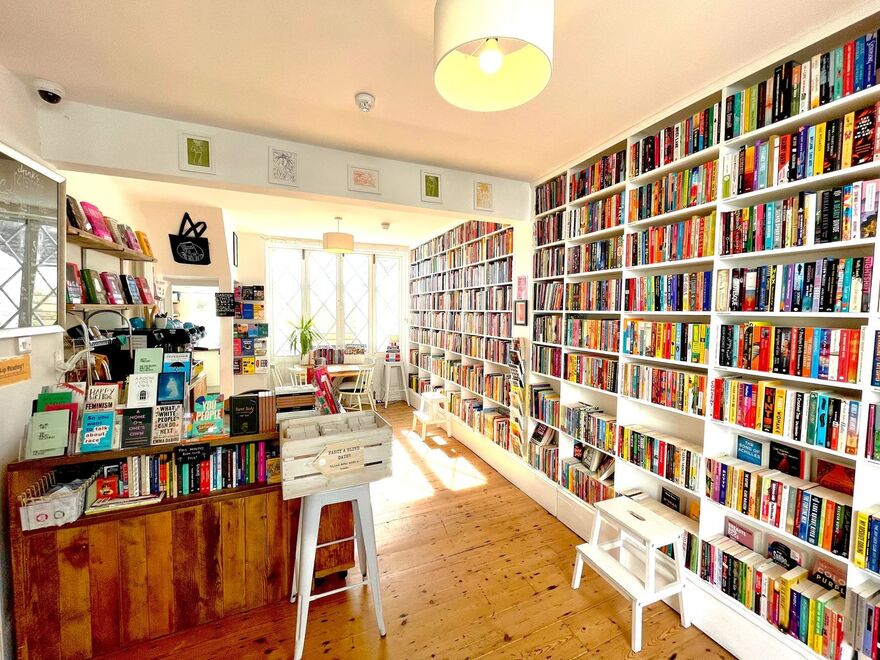 Inside of a bookshop, one wall lined with books