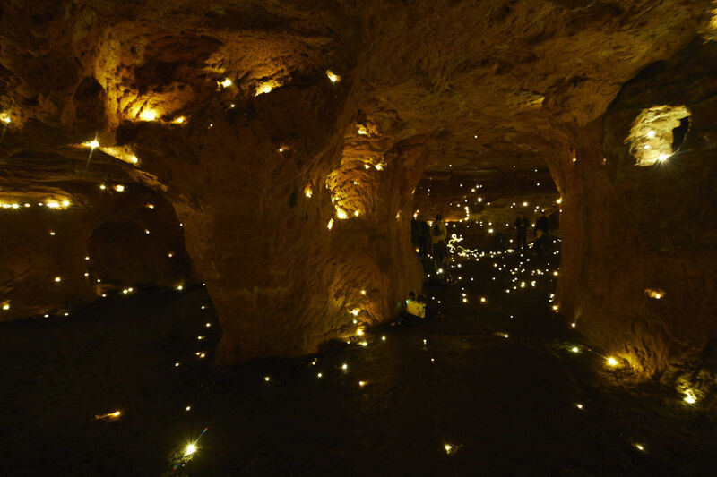 A cave with small lights scattered across the walls and floor