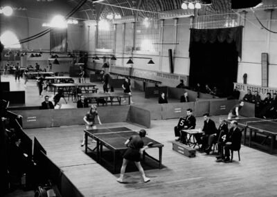 A greyscale heritage image of a table tennis competition taking place in Brighton Dome Corn Exchange.