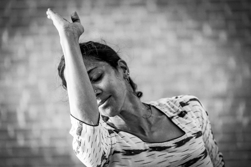 A female dancer inclining her head to the left as she moves