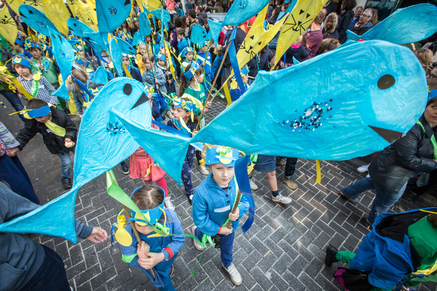 A group of children holding blue fish at the Children's Parade