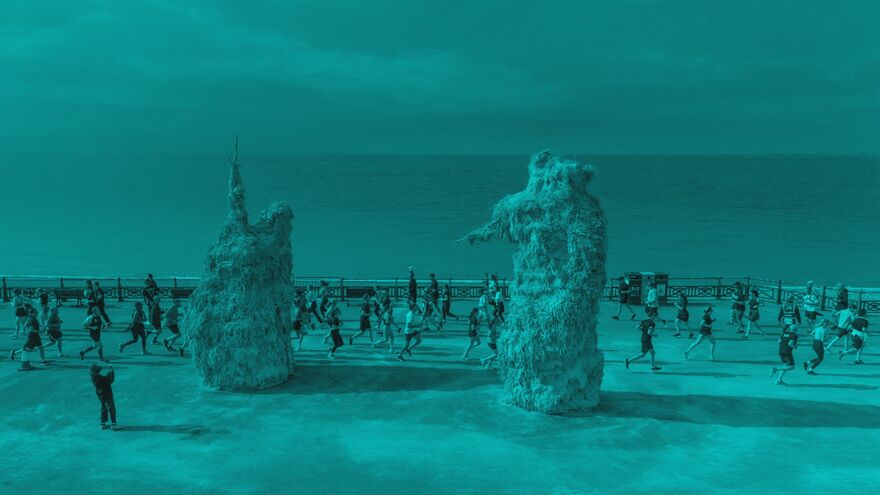 Two large sculptures on hove seafront with a park run running past